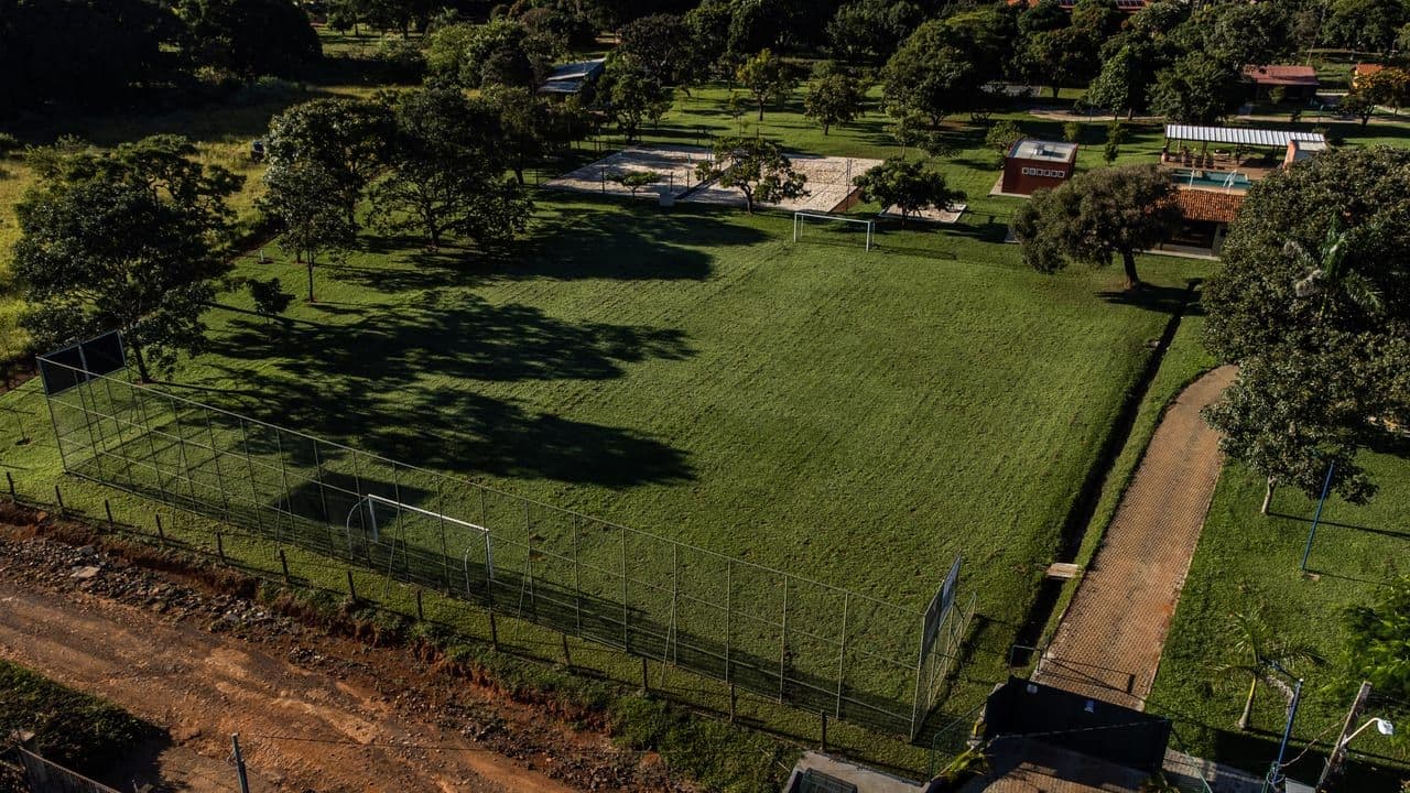 Campo gramado, quadras de areia, piscinas e vestiário